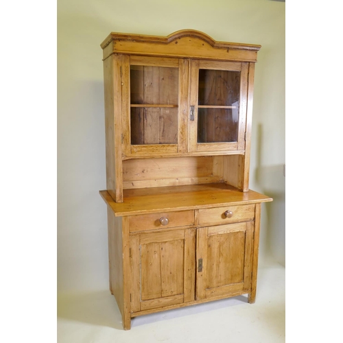 1040 - A C19th continental pine dresser, the upper section with two glazed doors, the base with two drawers... 