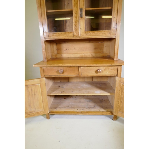 1040 - A C19th continental pine dresser, the upper section with two glazed doors, the base with two drawers... 