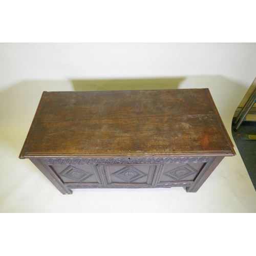 1047 - An C18th/C19th carved oak coffer with a plank top, adapted, 132 x 60cm high