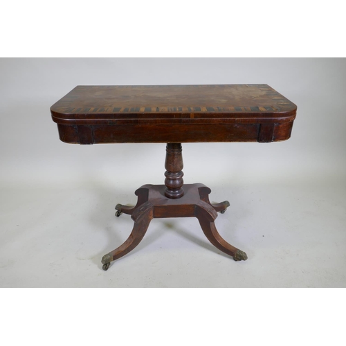 1052 - A Regency rosewood card table with Zebra wood crossbanded top, raised on a turned column with raised... 