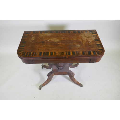 1052 - A Regency rosewood card table with Zebra wood crossbanded top, raised on a turned column with raised... 