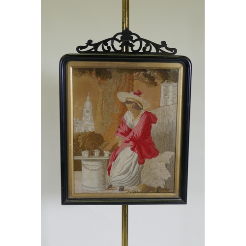 1053 - A C19th adjustable pole screen, the ebonised frame with open fretwork crest housing a Regency silk e... 