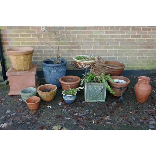 1064 - A quantity of terracotta, reconstituted stone and composition plant pots and planters, some with wro... 