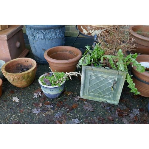 1064 - A quantity of terracotta, reconstituted stone and composition plant pots and planters, some with wro... 