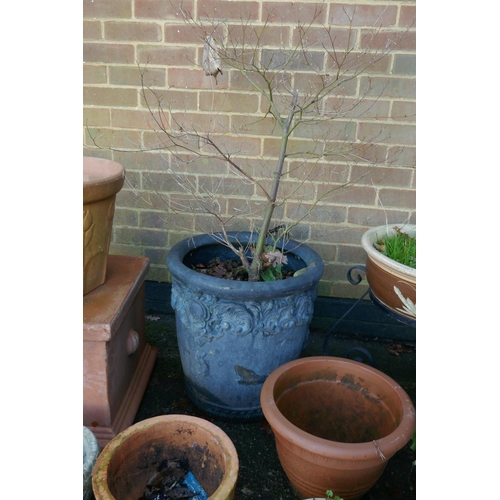 1064 - A quantity of terracotta, reconstituted stone and composition plant pots and planters, some with wro... 