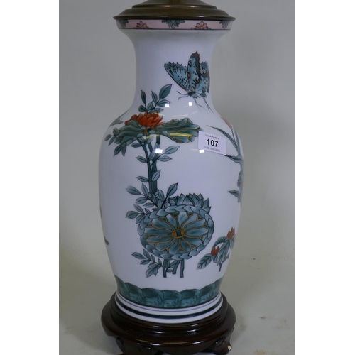 107 - A porcelain table lamp with butterfly and lotus flower decoration in the Chinese manner, 57cm high