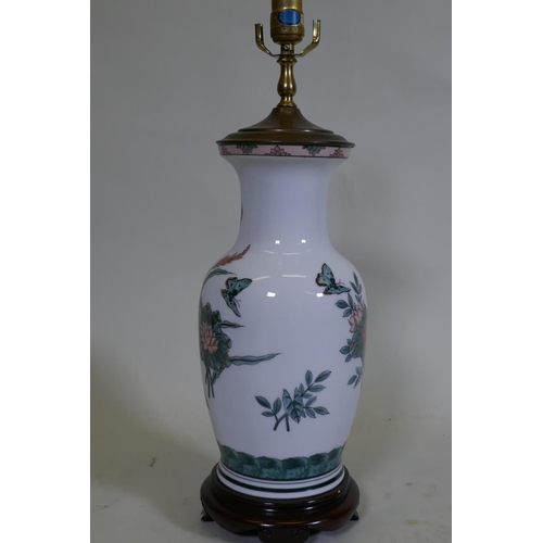 107 - A porcelain table lamp with butterfly and lotus flower decoration in the Chinese manner, 57cm high