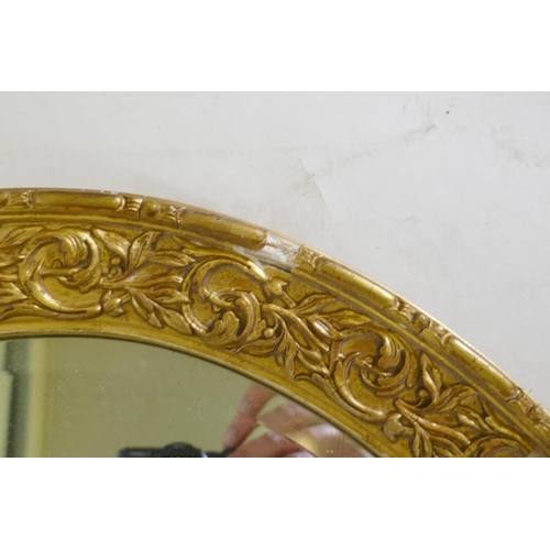 1070 - A gilt composition oval wall mirror, 59 x 86cm