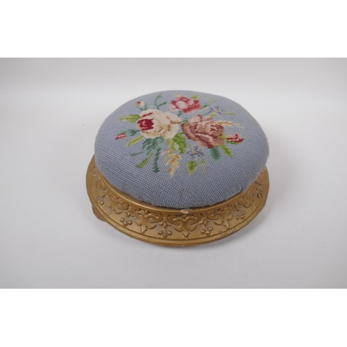 1071 - An antique gilt footstool with floral embossed pad, 30cm diameter