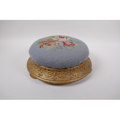 1071 - An antique gilt footstool with floral embossed pad, 30cm diameter