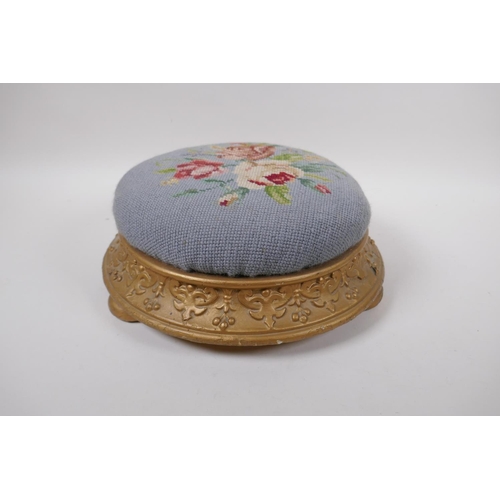 1071 - An antique gilt footstool with floral embossed pad, 30cm diameter