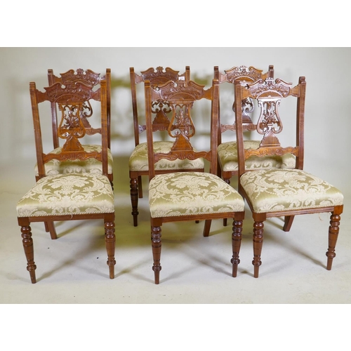 1072 - A set of six Edwardian oak dining chairs with carved and pierced lyre backs, turned supports and sab... 