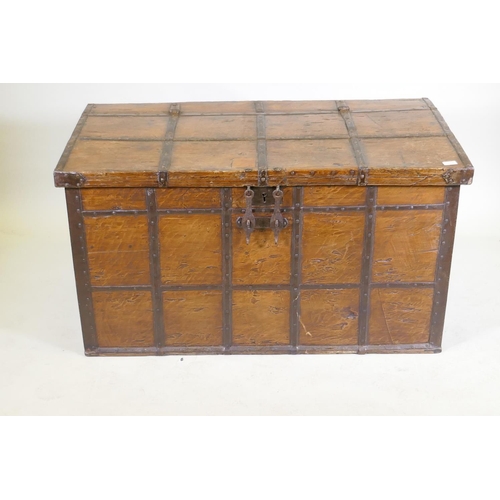 1079 - An antique Indian teak coffer with iron strapwork, carrying handles and hasps, 121 x 64 x 66cm