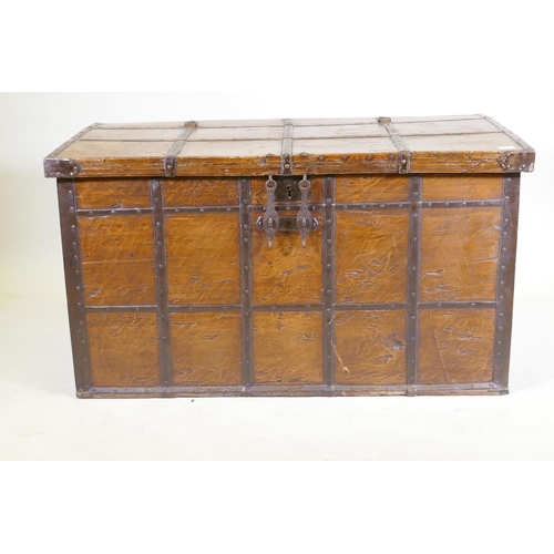 1079 - An antique Indian teak coffer with iron strapwork, carrying handles and hasps, 121 x 64 x 66cm