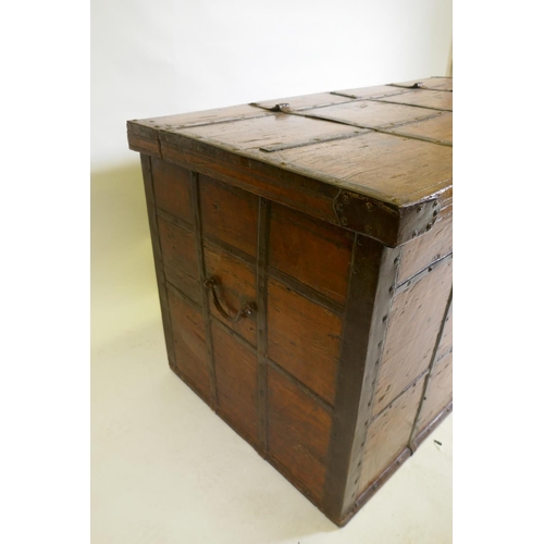 1079 - An antique Indian teak coffer with iron strapwork, carrying handles and hasps, 121 x 64 x 66cm