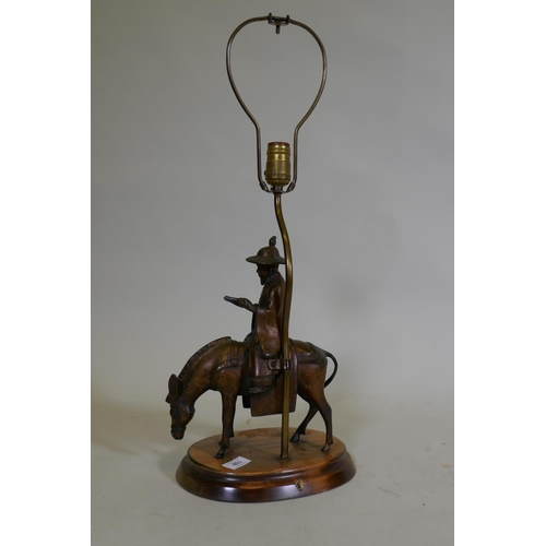 108 - A vintage table lamp in the form of an oriental gentleman riding a mule, mounted on a wood base, 63c... 