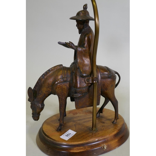 108 - A vintage table lamp in the form of an oriental gentleman riding a mule, mounted on a wood base, 63c... 