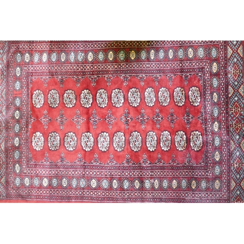 1080 - A red ground wool Bokharra rug, 128 x 196cm