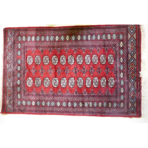 1080 - A red ground wool Bokharra rug, 128 x 196cm