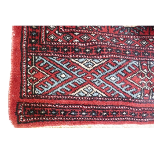 1080 - A red ground wool Bokharra rug, 128 x 196cm