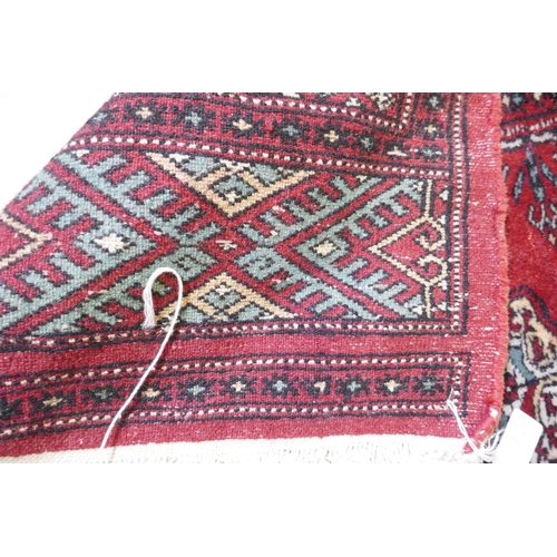 1080 - A red ground wool Bokharra rug, 128 x 196cm