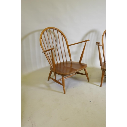 1081 - A pair of mid century Ercol beechwood hoopback elbow chairs with solid seats, 83cm