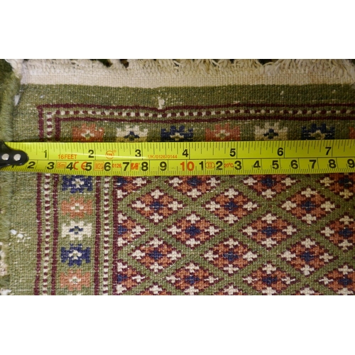 1087 - A fine woven green ground Turkish rug with an allover Bokharra style design, 130 x 182cm