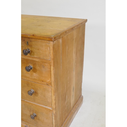 1091 - A C19th pine nine drawer kneehole desk with central cupboard raised on a shaped plinth base, 110 x 5... 