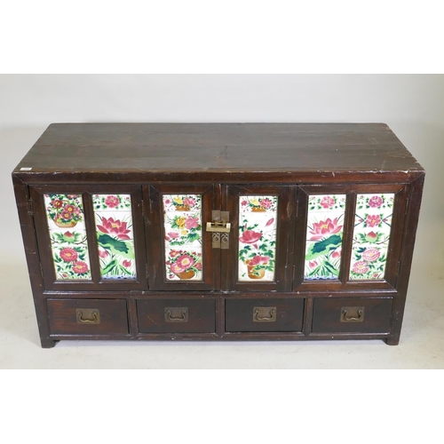 1093 - An antique Chinese stained elm side cabinet with two cupboards fitted with folding doors, inset with... 