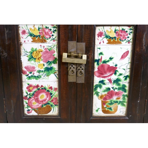 1093 - An antique Chinese stained elm side cabinet with two cupboards fitted with folding doors, inset with... 