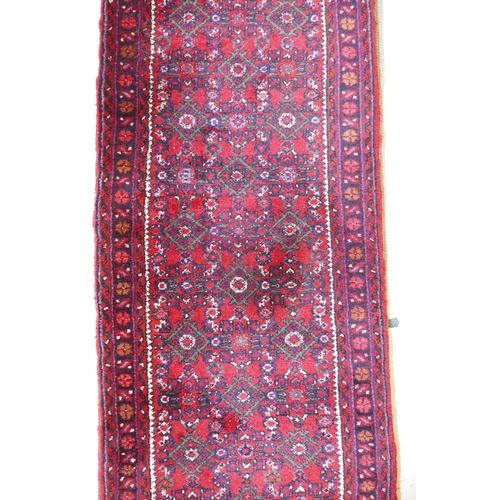 1095 - A Persian red ground full pile wool runner with an allover geometric design, 195 x 70cm