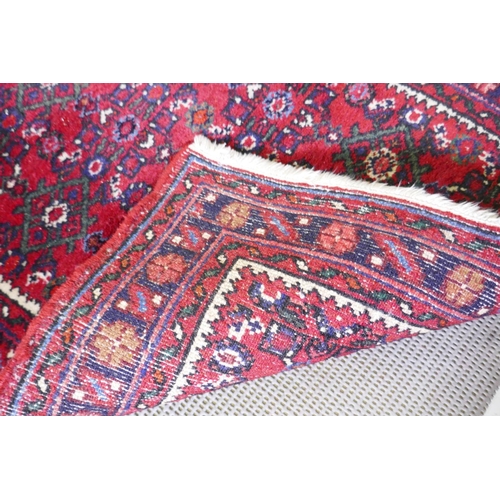 1095 - A Persian red ground full pile wool runner with an allover geometric design, 195 x 70cm