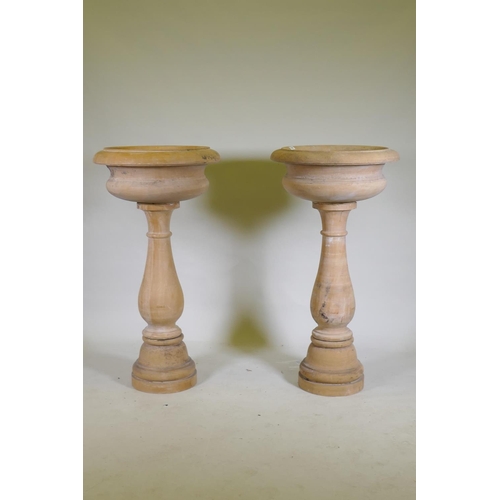 1096 - A pair of stone urns/planters raised on baluster columns, 60cm diameter, 111cm high