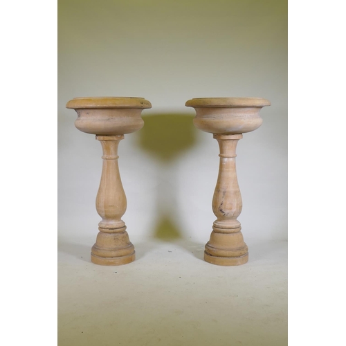 1096 - A pair of stone urns/planters raised on baluster columns, 60cm diameter, 111cm high