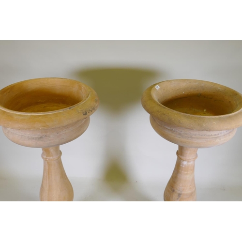 1096 - A pair of stone urns/planters raised on baluster columns, 60cm diameter, 111cm high