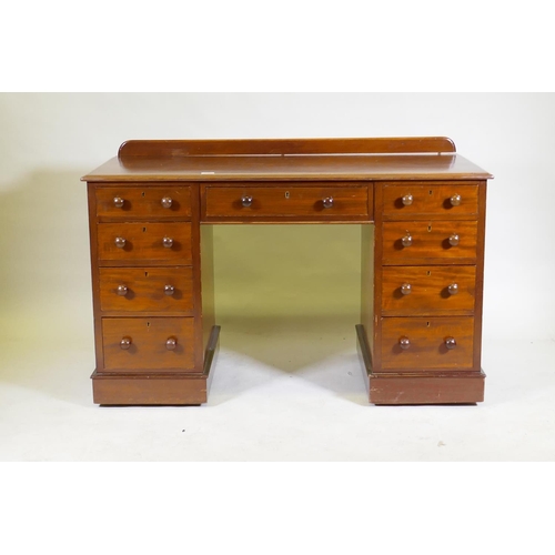 1097 - A C19th mahogany nine drawer kneehole desk with original locks and turned wood handles, raised on a ... 