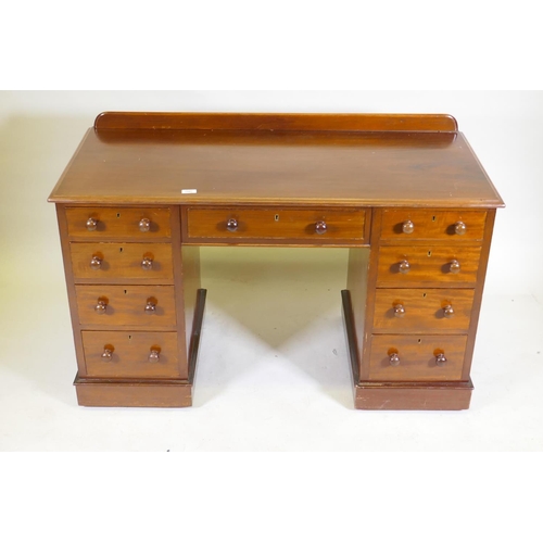 1097 - A C19th mahogany nine drawer kneehole desk with original locks and turned wood handles, raised on a ... 