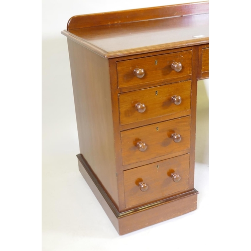 1097 - A C19th mahogany nine drawer kneehole desk with original locks and turned wood handles, raised on a ... 