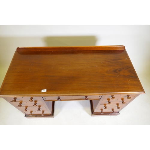 1097 - A C19th mahogany nine drawer kneehole desk with original locks and turned wood handles, raised on a ... 