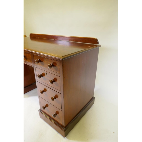 1097 - A C19th mahogany nine drawer kneehole desk with original locks and turned wood handles, raised on a ... 