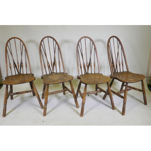 1100 - A set of four hoop back Windsor chairs with high backs and shaped solid elm seats, raised on turned ... 