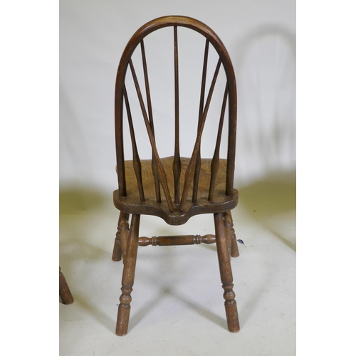 1100 - A set of four hoop back Windsor chairs with high backs and shaped solid elm seats, raised on turned ... 