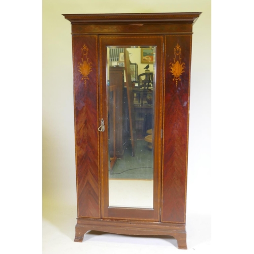 1103 - A Victorian inlaid mahogany single door wardrobe with bevelled glass mirror, raised on swept support... 