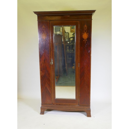 1103 - A Victorian inlaid mahogany single door wardrobe with bevelled glass mirror, raised on swept support... 