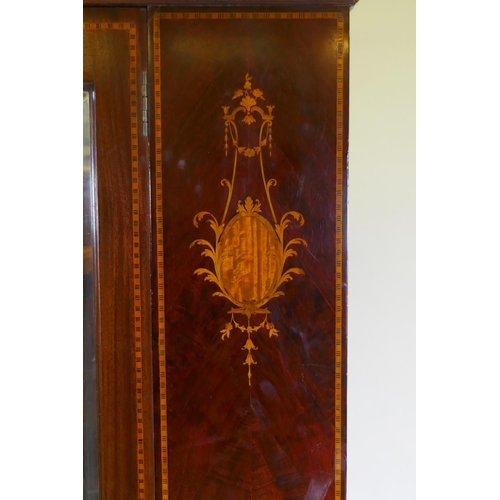 1103 - A Victorian inlaid mahogany single door wardrobe with bevelled glass mirror, raised on swept support... 