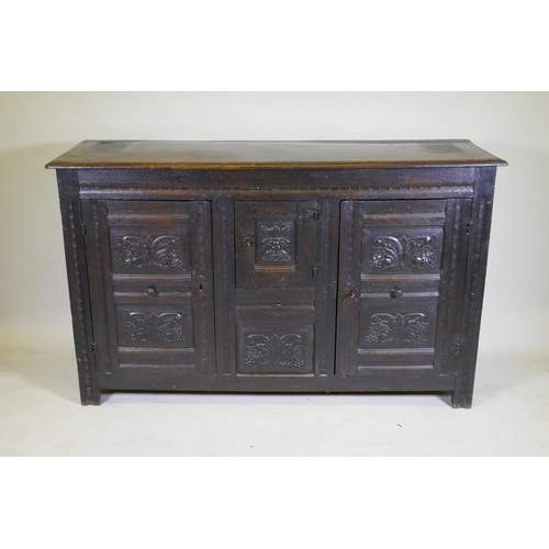 1108 - An C18th continental bog oak dresser/buffet with three cupboards and fielded carved panels with Gree... 