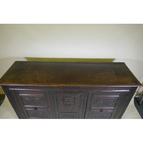 1108 - An C18th continental bog oak dresser/buffet with three cupboards and fielded carved panels with Gree... 