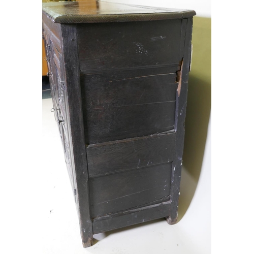 1108 - An C18th continental bog oak dresser/buffet with three cupboards and fielded carved panels with Gree... 