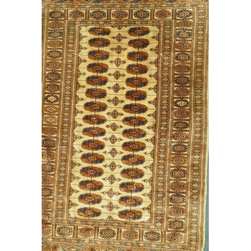 1110 - A Bokhara wool rug with geometric designs on a gold field, 180 x 120cm