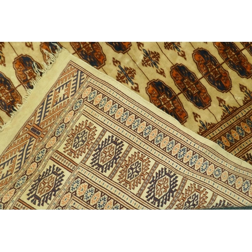 1110 - A Bokhara wool rug with geometric designs on a gold field, 180 x 120cm